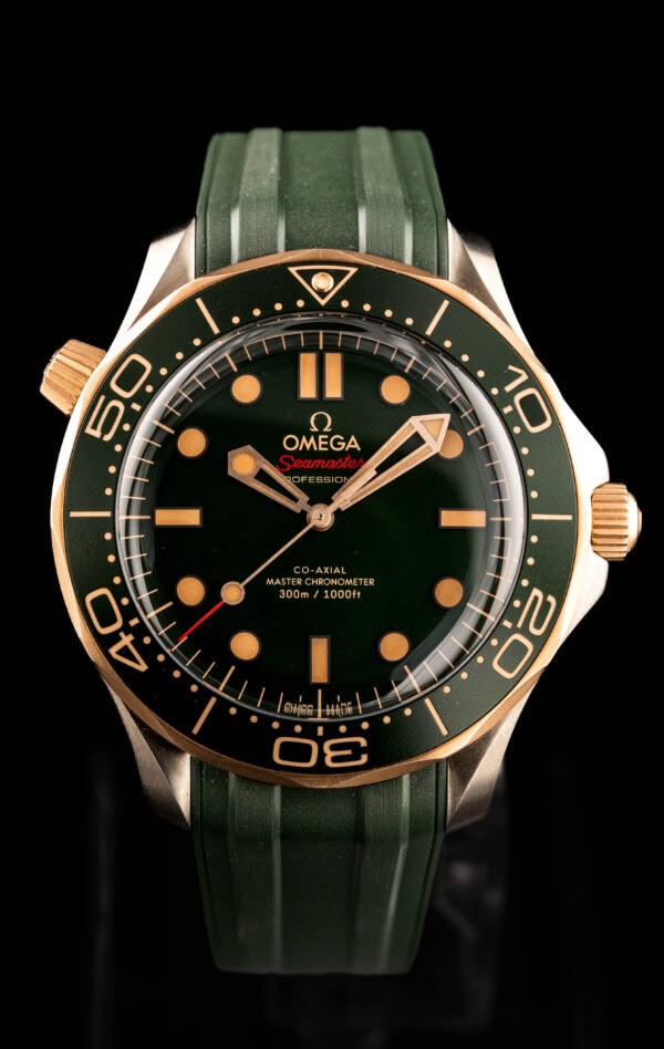 2025 Omega Seamaster Diver 300M ref. 210.92.42.20.10.001 in titanium and bronze gold with a green dial on a green rubber strap.
