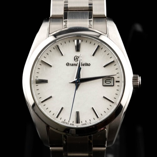 2025 Grand Seiko 9F62 quartz with textured white dial and blue seconds hand on steel bracelet