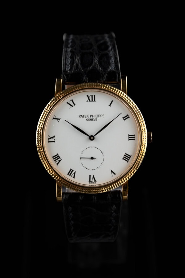 1993 Patek Philippe Calatrava 3919 in 18k yellow gold with white Roman dial and hobnail bezel on black leather strap